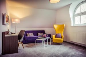 卑尔根露嘉德酒店的客厅配有紫色沙发和黄色椅子