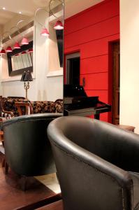 卡拉马塔银河酒店 的客厅配有钢琴和椅子