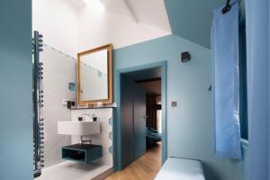 科尔马Hotel Le Colombier Suites的一间拥有蓝色墙壁、镜子和灯的房间