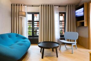 科尔马Hotel Le Colombier Suites的客厅配有蓝色的沙发和椅子