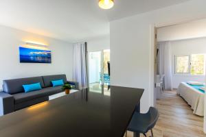 米乔尔海滩Pinos Playa Suites的客厅配有沙发和桌子