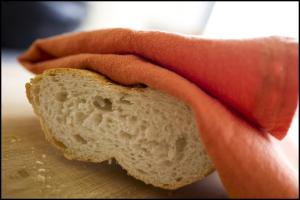 AartrijkeRooseboom22的把一块面包放在切板上的人