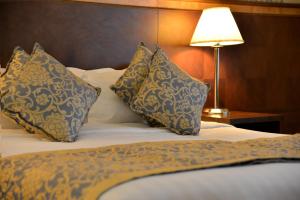 麦地那诺佐尔皇家酒店的一张带蓝色和白色枕头的床和一盏灯