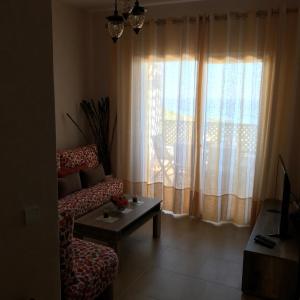 卡博尼格洛Appartement Bellavista - Cabo Negro的带沙发和窗户的客厅
