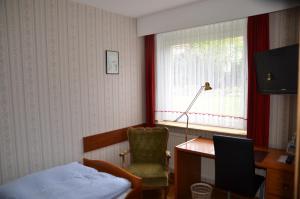 汉诺威瓦德西酒店的一间卧室配有一张床、一张桌子和一把椅子