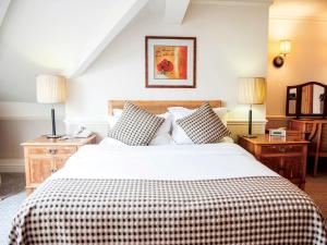 克努斯福德科腾斯酒店及Spa的一间卧室配有一张大床和一张 ⁇ 子毯子