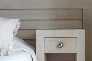埃尔莫波利斯埃斯佩兰斯1号酒店的一张带木制床头板的床和一个带抽屉的床头柜