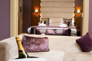 克努斯福德梅尔高尔夫度Spa度假酒店的客房设有两张床和一张带一瓶香槟的沙发。