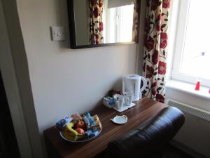 奥本Adelphi Villa的一张桌子,上面放着一碗水果和镜子