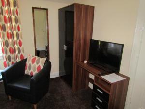 奥本Adelphi Villa的客厅配有电视、椅子和电视。