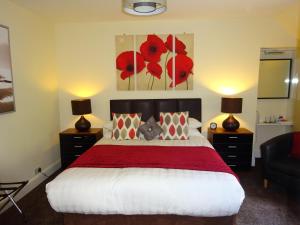 奥本Adelphi Villa的一间卧室配有一张带红毯的床和两盏灯。