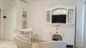 布宜诺斯艾利斯Loft Almagro的白色的客厅配有电视和书桌
