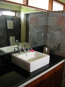 海神庙加湾别墅酒店的浴室设有白色水槽和镜子