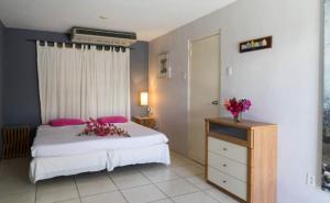 Santa CatharinaTropical Breeze Curaçao的一间卧室配有床和鲜花梳妆台。