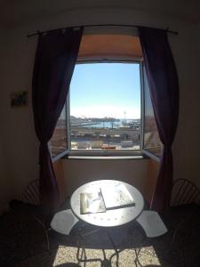 热那亚B&B Al Fronte del Porto的美景大窗户前的桌子