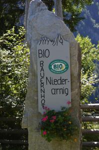 大格洛克纳山麓卡尔斯Ferienwohnungen Niederarnigerhof Familie Bauernfeind的岩石上的一个花签