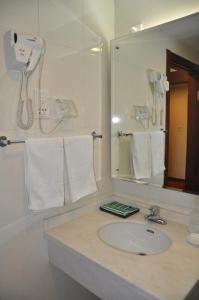 北京北京华育宾馆的浴室配有盥洗盆、镜子和毛巾