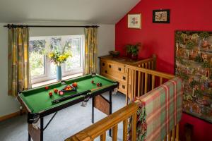 Pontardawe1 Tan Yr Eglwys Barn Cottage的一间带台球桌和婴儿床的房间