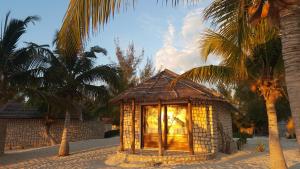 Andavadoaka拉古娜布鲁 - 马达加斯加度假酒店的棕榈树海滩上的一座小建筑