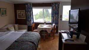锡谢尔特水湾上方旅馆的一间卧室配有一张床、一张桌子和一个窗户。
