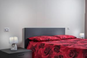 韦尔巴尼亚Residenza Intra Lago Maggiore的一间卧室配有一张红色的床,配有黑色床头板和红色床单