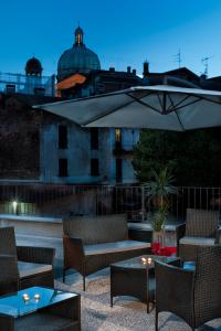 韦尔巴尼亚Residenza Intra Lago Maggiore的庭院配有桌椅和遮阳伞。