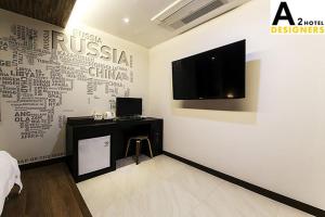 Yesan德新格A2酒店的客房设有带电视和书桌的墙壁。