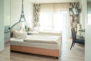 汉诺威汉诺威朗根哈根氛围酒店 - 郁金香酒店管理的卧室内的两张床和艾菲尔铁塔