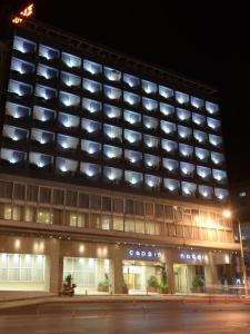 塞萨洛尼基赛龙尼凯普斯酒店的一座大型建筑,晚上有很多窗户