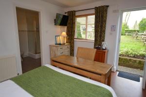 汉普顿茵雅顿白狮旅馆的一间卧室配有一张床、一张书桌和一个窗户。