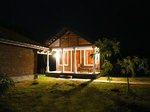 帕西库达Pasikudah Eco Village Hotel的夜晚在屋前有灯的房子