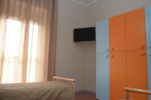 庞贝Calabrese Family的一间卧室配有一张床、一个橱柜和一台电视