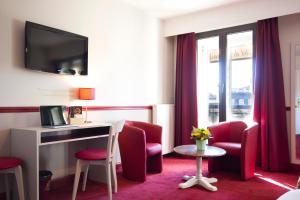 波尔多DES四姐妹酒店的酒店客房配有红色的椅子、书桌和窗户。