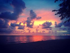 象岛15 Palms Beach Resort的日落在海滩上与大海