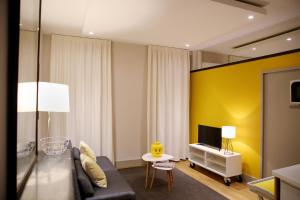 阿尔比Appartements Numeroa的客厅设有黑色沙发和黄色的墙壁