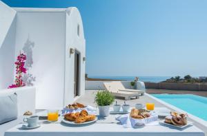 易莫洛林Azar Luxury Villas & Suites的一张桌子,上面有食物,放在游泳池边