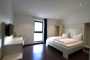 PlankstadtNeumann's Übernachten的卧室配有白色的床和电视。