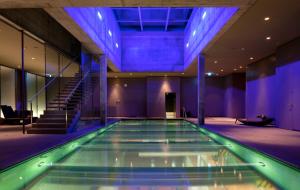 圣加仑爱因斯坦圣加仑酒店的蓝色灯光的建筑中的游泳池