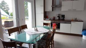 图尔恩Privatzimmer Jarosch的厨房以及带玻璃桌和椅子的用餐室