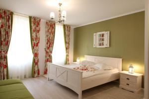 锡比乌Casa Hermanni的卧室配有白色床、绿色墙壁和窗户