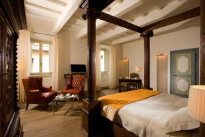诺尔恰城堡塞内卡宫罗莱夏朵精品酒店的一间卧室设有一张床和一间客厅。