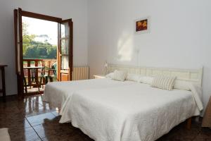 柯米拉斯索拉托尔酒店的一间带白色床的卧室和一个阳台