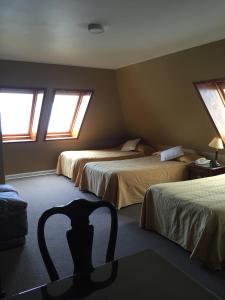 蒙特港科隆公寓式酒店的一间卧室配有两张床和椅子