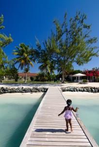 The Settlement阿内加达岛礁酒店的一个小女孩在水面上的木桥上行走