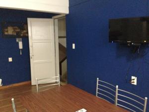 梅塞德斯Apartamento en el centro de mercedes URUGUAY的一间设有蓝色墙壁、电视和门的房间
