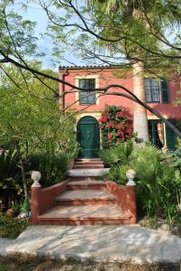 芒通橄榄树下酒店的前面有一道绿色的门和楼梯的房子