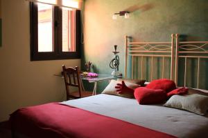 拉拉古纳Luxury house in the heart of Tenerife的一间卧室配有一张带红色枕头的床和一张桌子