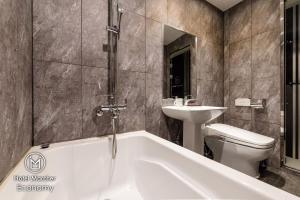 釜山行军酒店的带浴缸、盥洗盆和卫生间的浴室