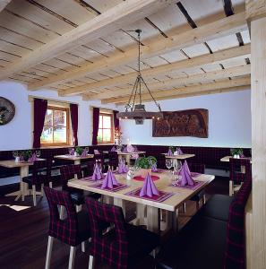 塞尔瓦迪加尔代纳山谷Apartments Restaurant Rusctlea的用餐室配有带紫色餐巾的桌子和椅子