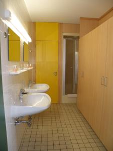 巴特莱昂费尔登索默豪斯酒店 的浴室设有两个水槽和黄色的墙壁